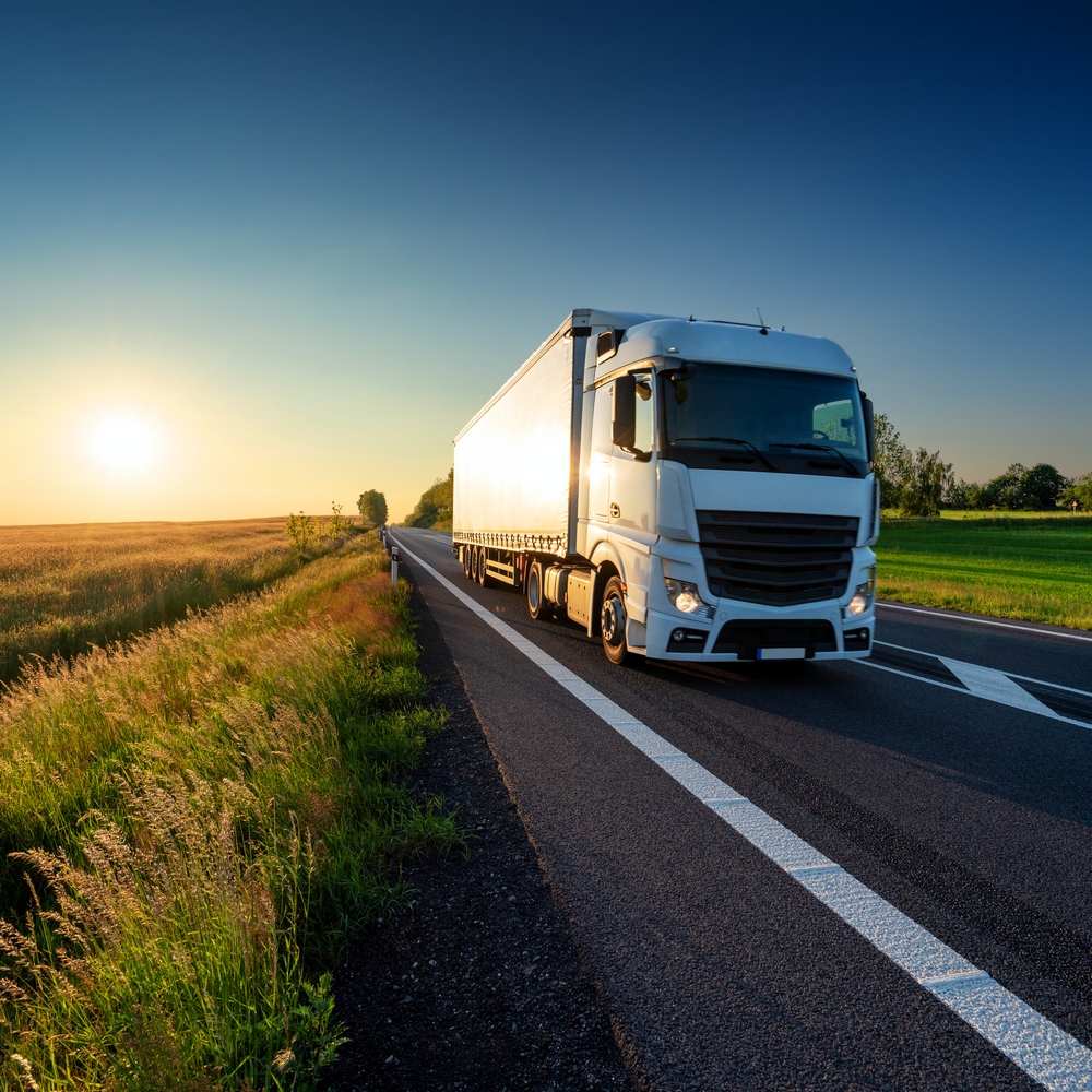 Camion de transport sur une route rurale au coucher du soleil